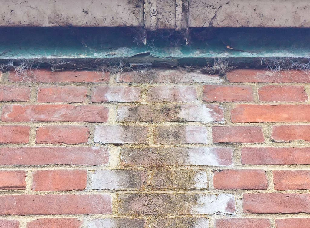 water damage on brickwork caused by a leaking gutter joint