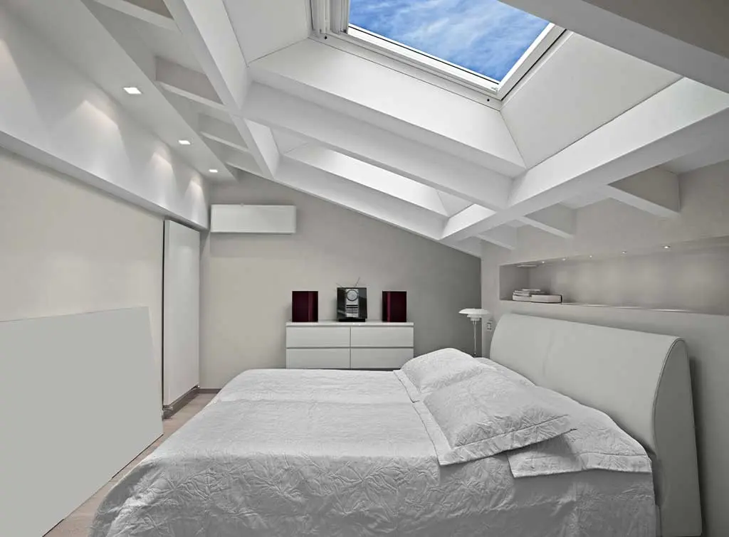 Naturally light loft bedroom with recessed ceiling downlights and large VELUX windows
