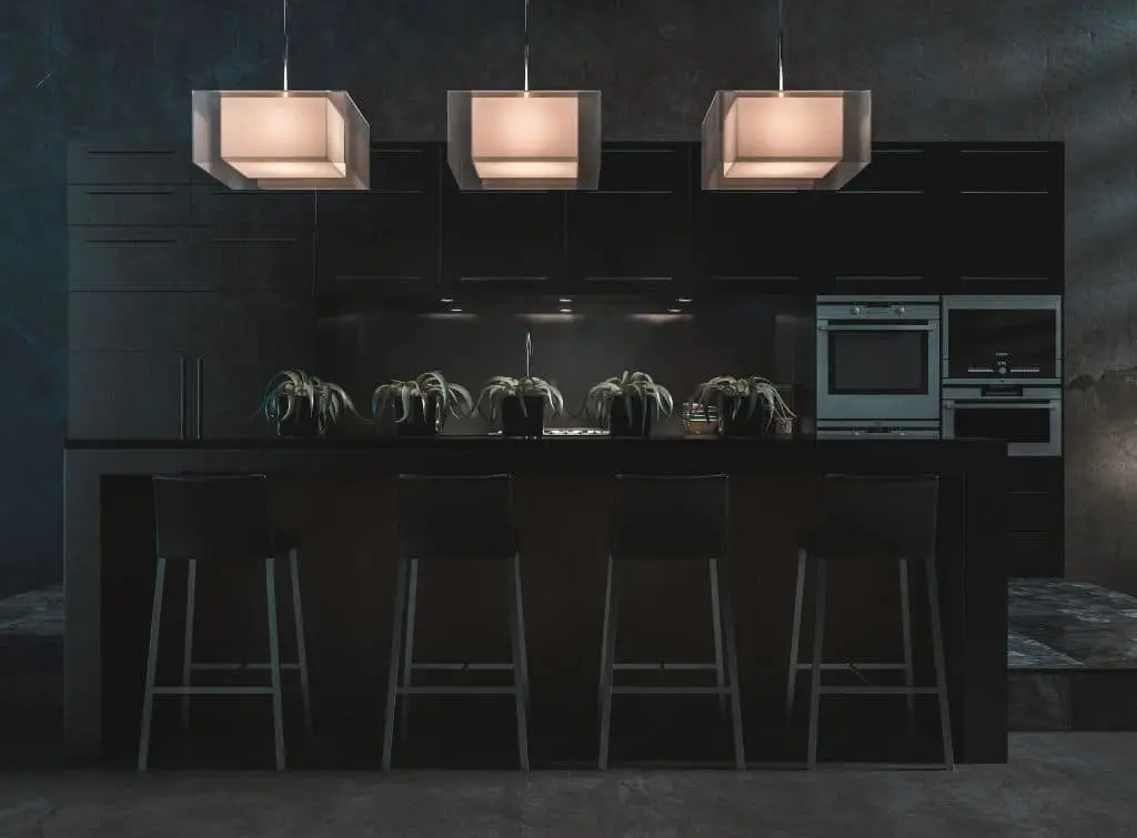 Dark walls in a moody kitchen with soft hanging lights