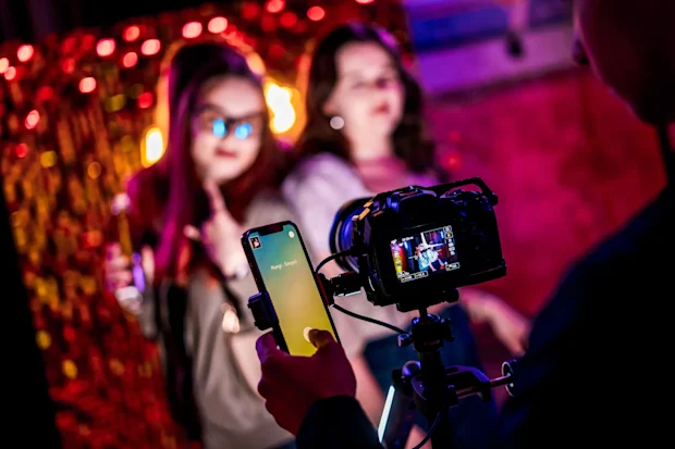 Mosolygó vendégek és segítőkész munkatárs a 360 Selfie Spinner elindítása előtt egy céges eseményen