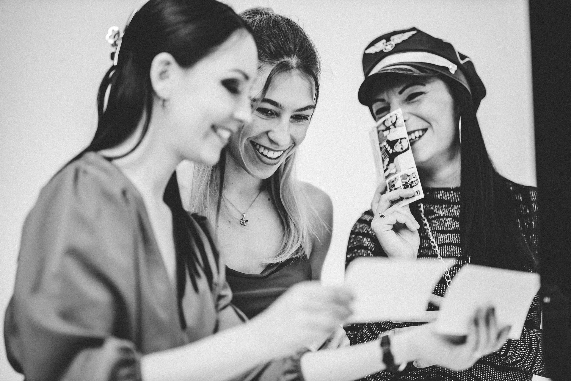 Vendégek nevetve nézik a Selfie Zone fotóautomata által azonnal kinyomtatott képeket.