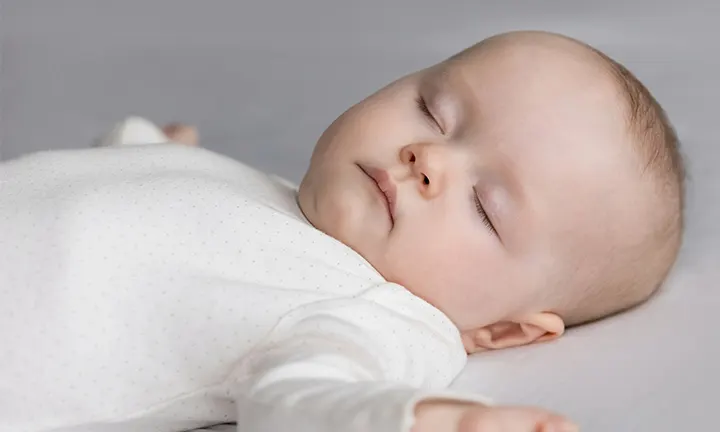 Baby in white bodysuit dreaming