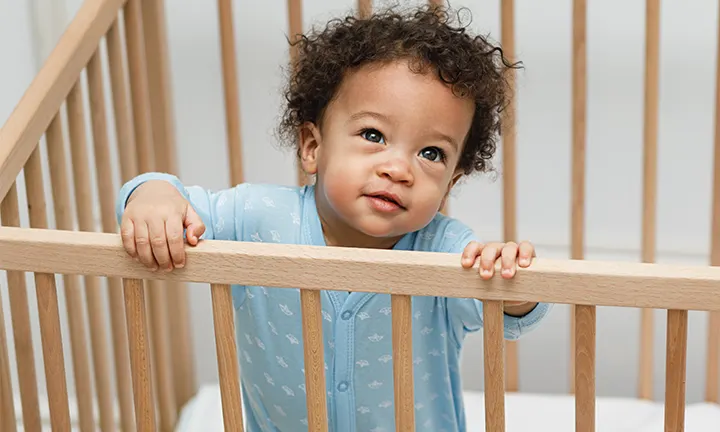 Baby boy standing in crib