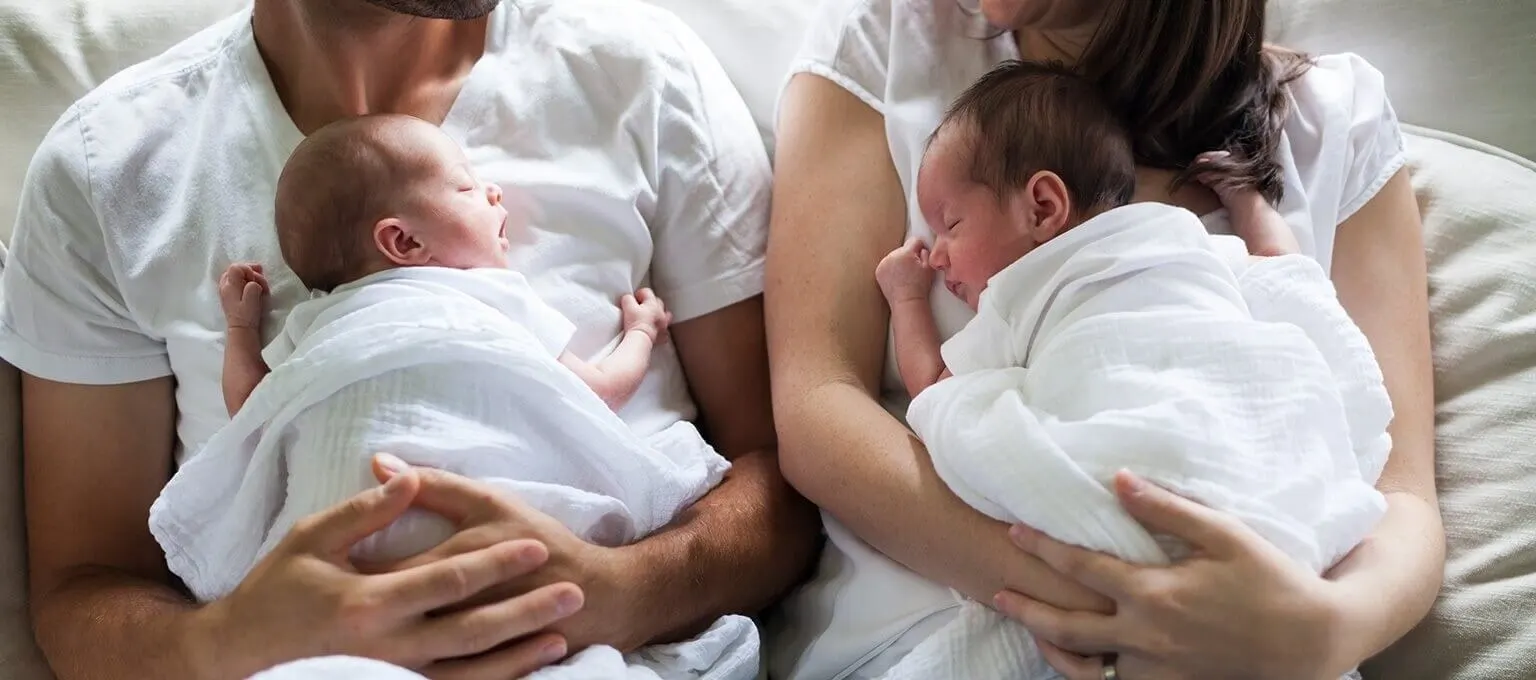 Parents holding their newborn twins 