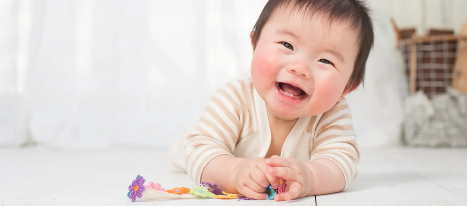 Baby smiling and playing with toy