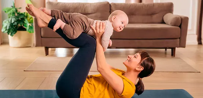 Mamá haciendo ejercicios posparto con su bebé