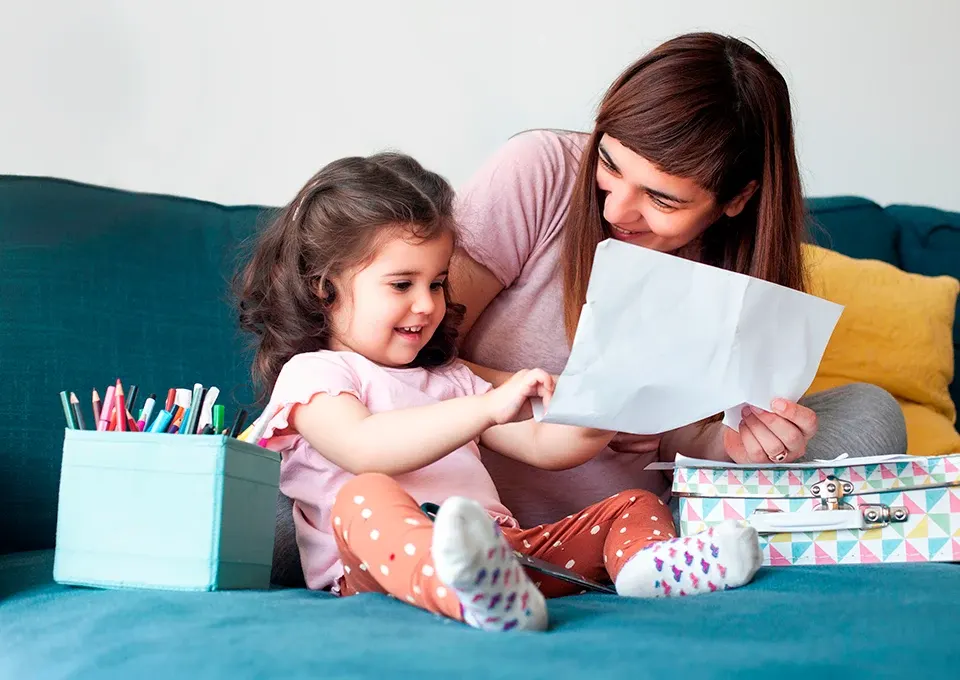 Niña dibujando con su mamá