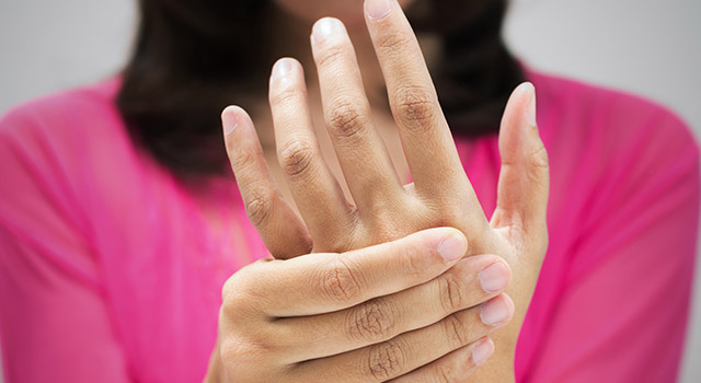 Mulher pressionando as mãos por falta de vitaminas Neurobión