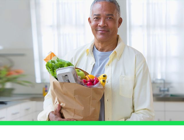 hombre sonriendo con compras de supermercado