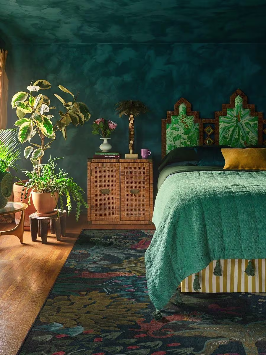 Ruggable x Justina Blakeney Josphine Midnight washable rug in teal bedroom with house plants and tassled bedspread