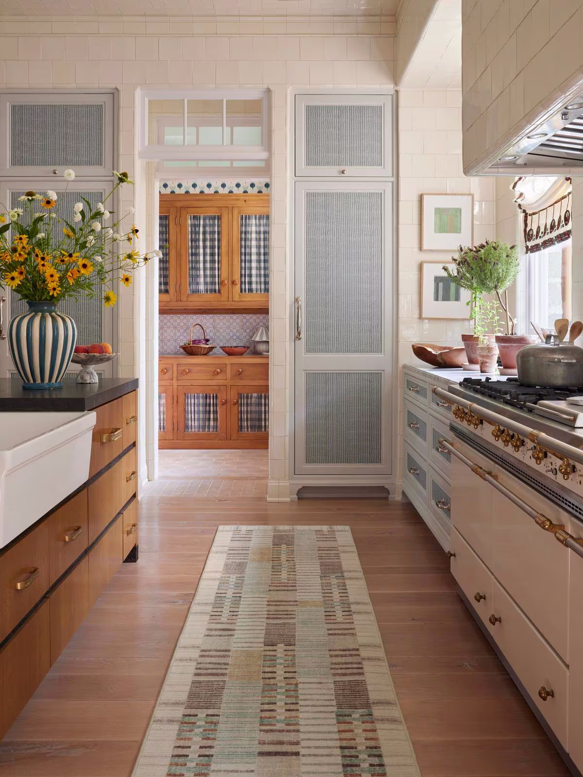 Image of a cottage-style kitchen with light blue accents, wood flooring, and the Ruggable x Architectural Digest Selene Neutral Multicolor Rug.
