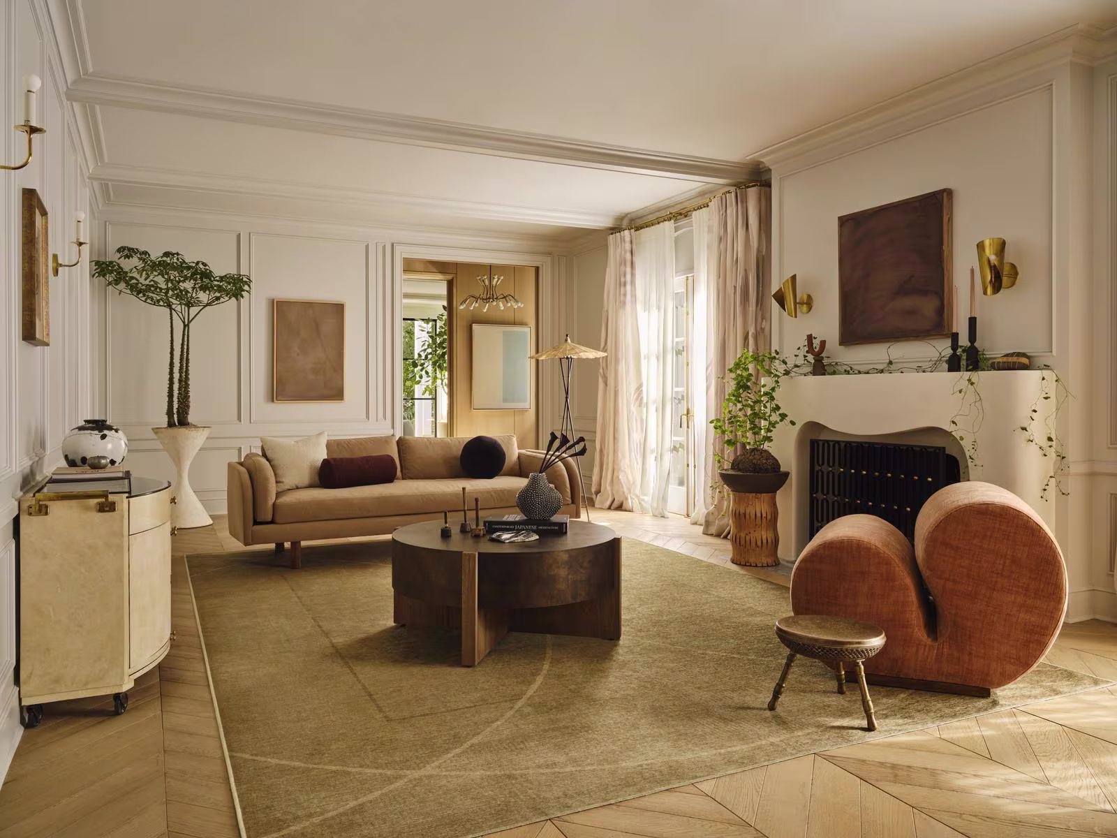 Image of a warm living room with curvaceous furniture and a palette of golds, burnt orange, and copper, featuring the Ruggable x Architectural Digest Ayla Gold Rug. 