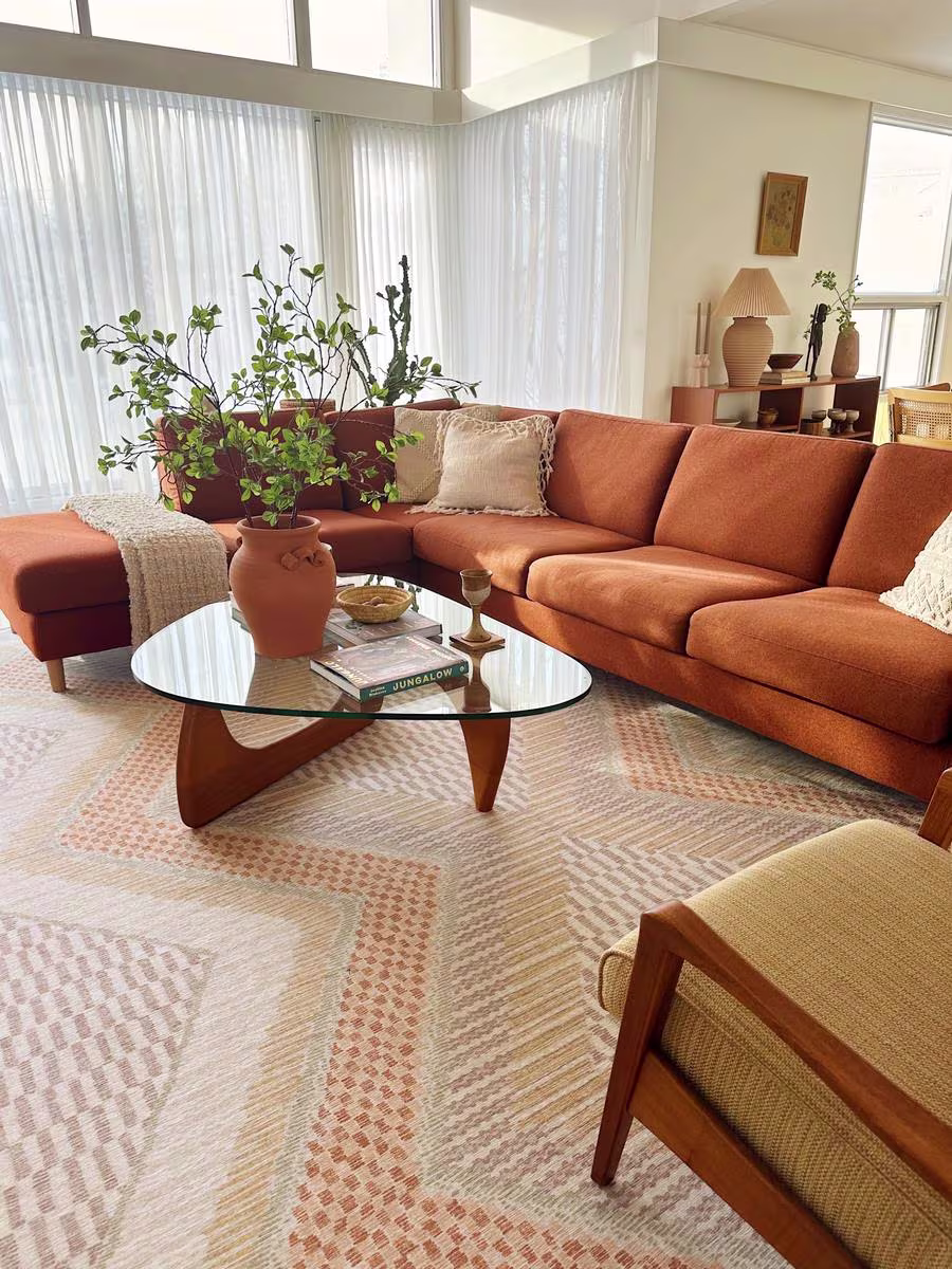 Ruggable x Justina Blakeney Etta Natural & Terra washable rug in living room of @thezielkehome with rust sofa and glass coffee table with Jungalow coffee table book