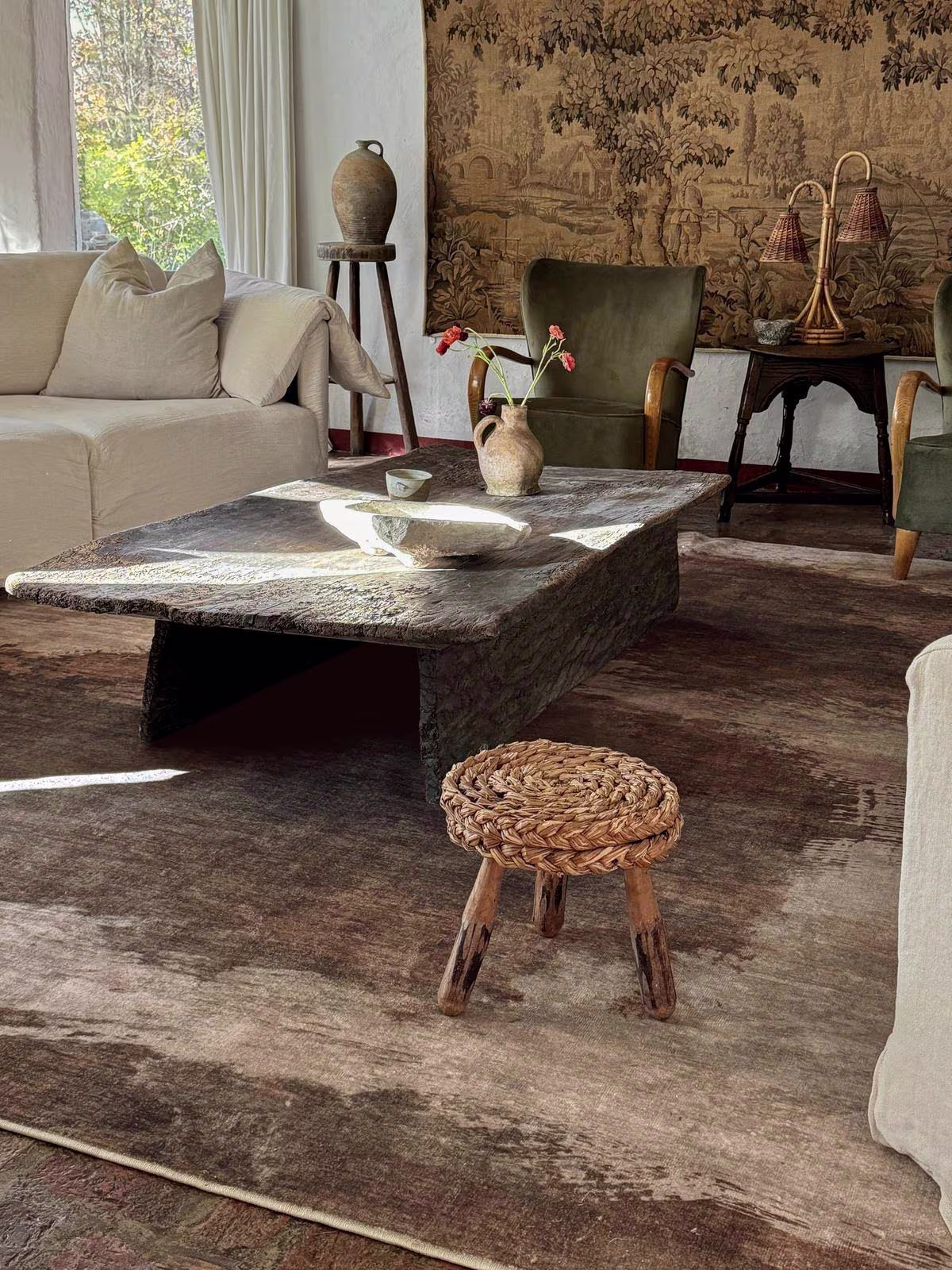 Image of light-filled living room with textured wood finishes, natural fibers, and earthy tones. 