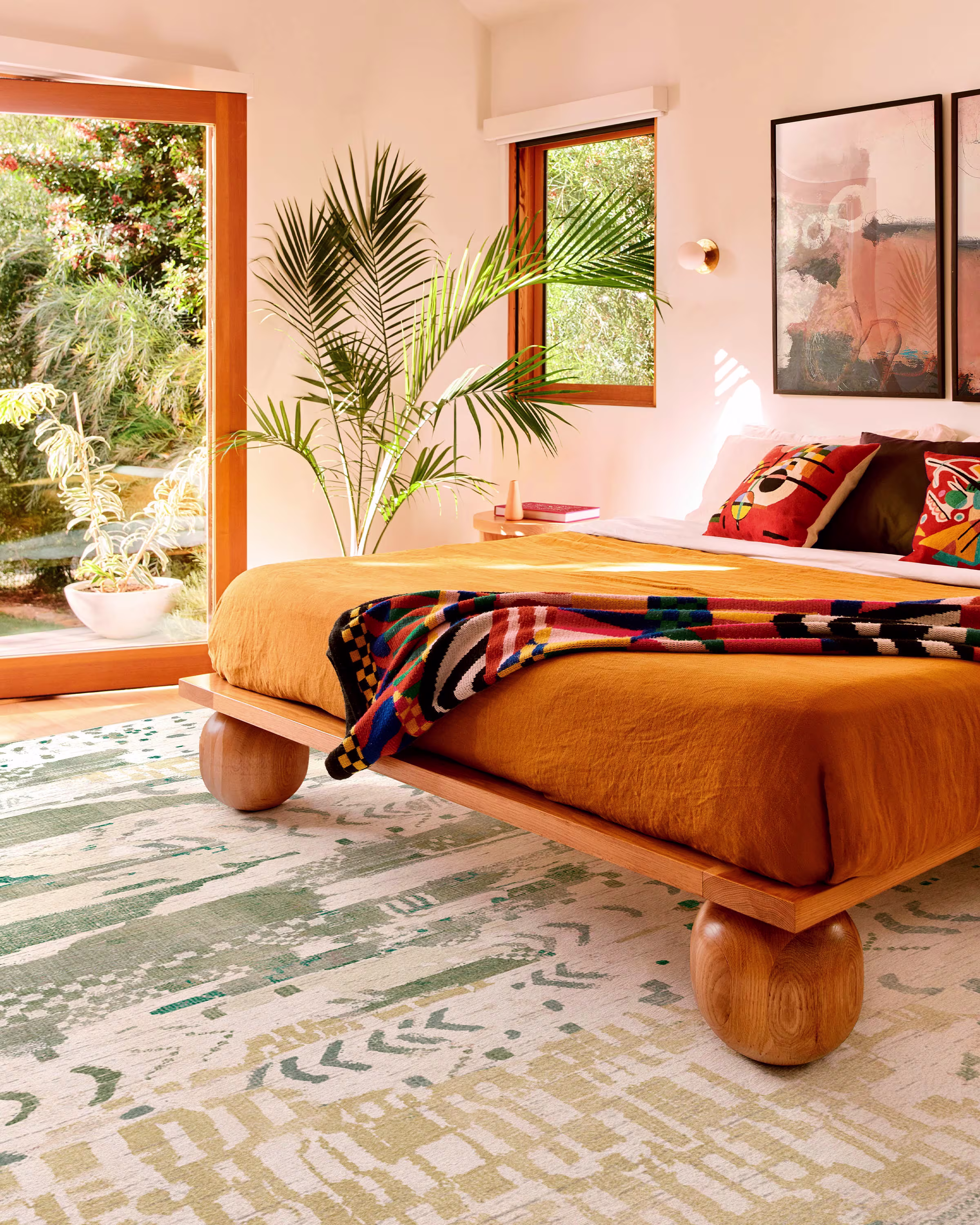 Mustard yellow bed styled with olive green and yellow boho rug