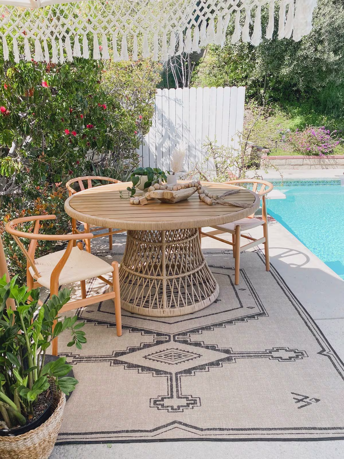 Ruggable Sierra Black & Sand Re-Jute Rug in outdoor dining setting next to swimming pool