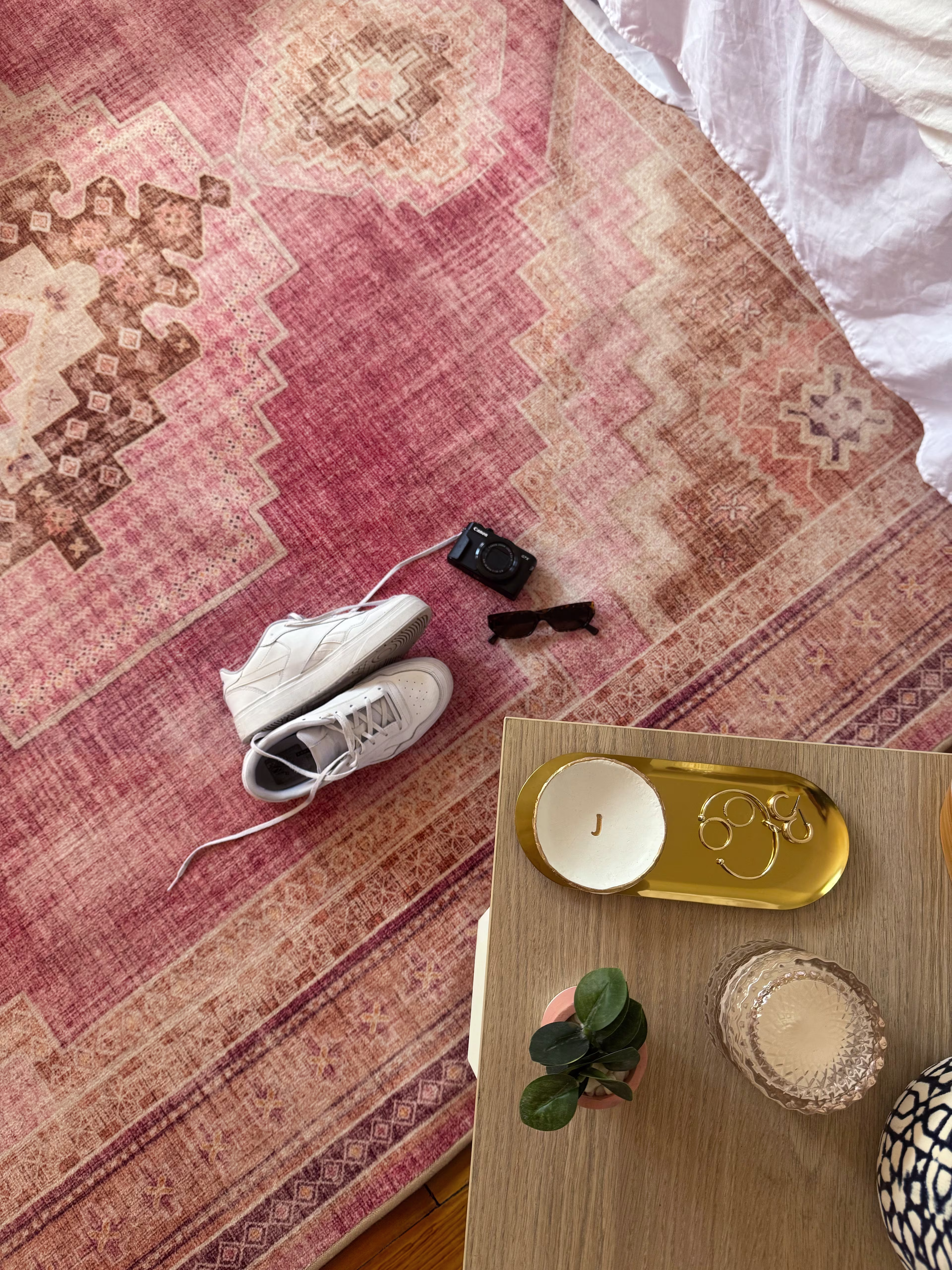 Pink boho rug styled with decor and side table in cozy room