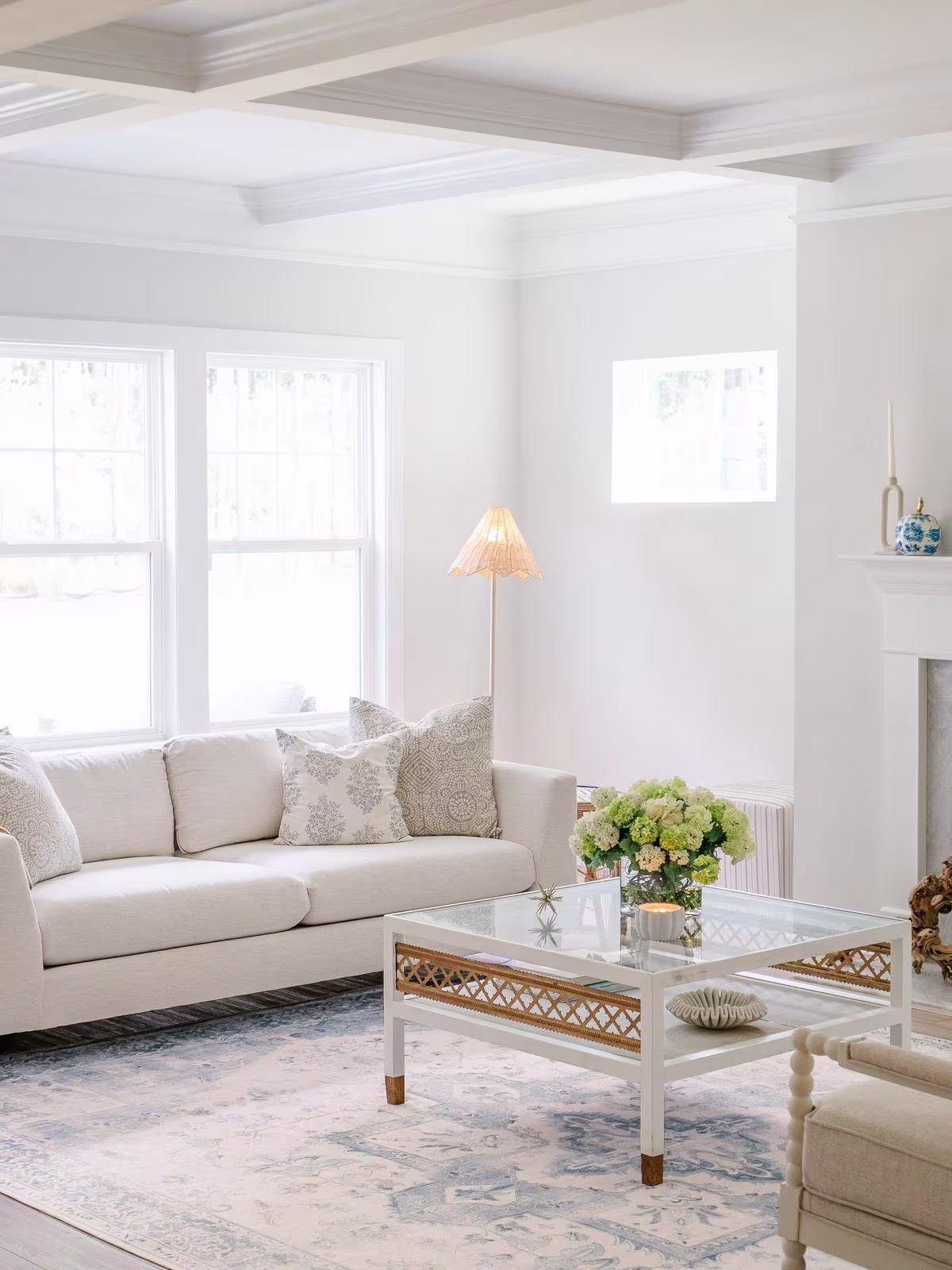 Ruggable washable Kira Soft Blue Rug in coastal living room with ceiling beams, white furniture, and rattan accents