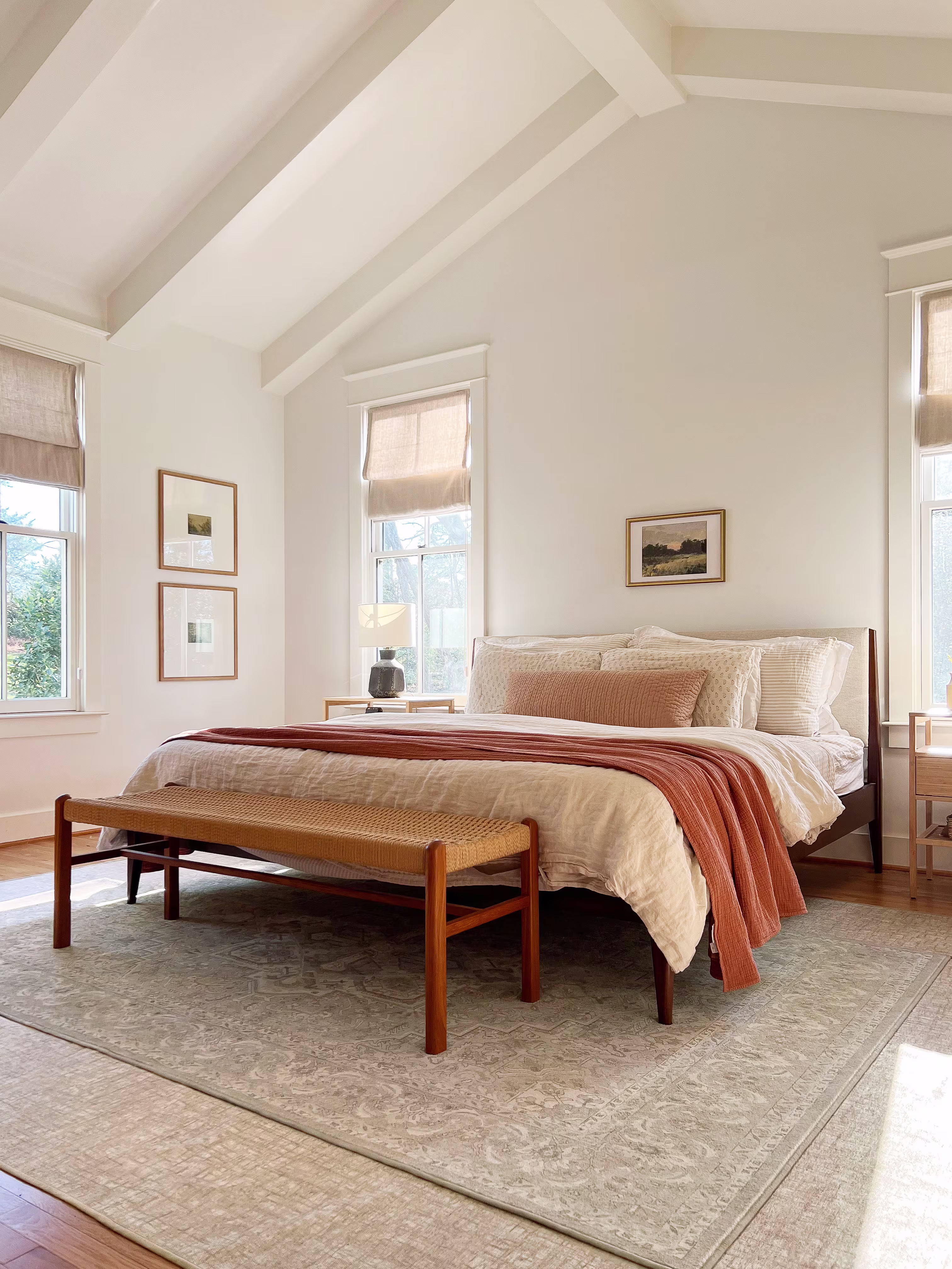 Layered bedroom rugs featuring a large neutral base rug under the bed with a smaller rug layered on top for added texture and warmth.