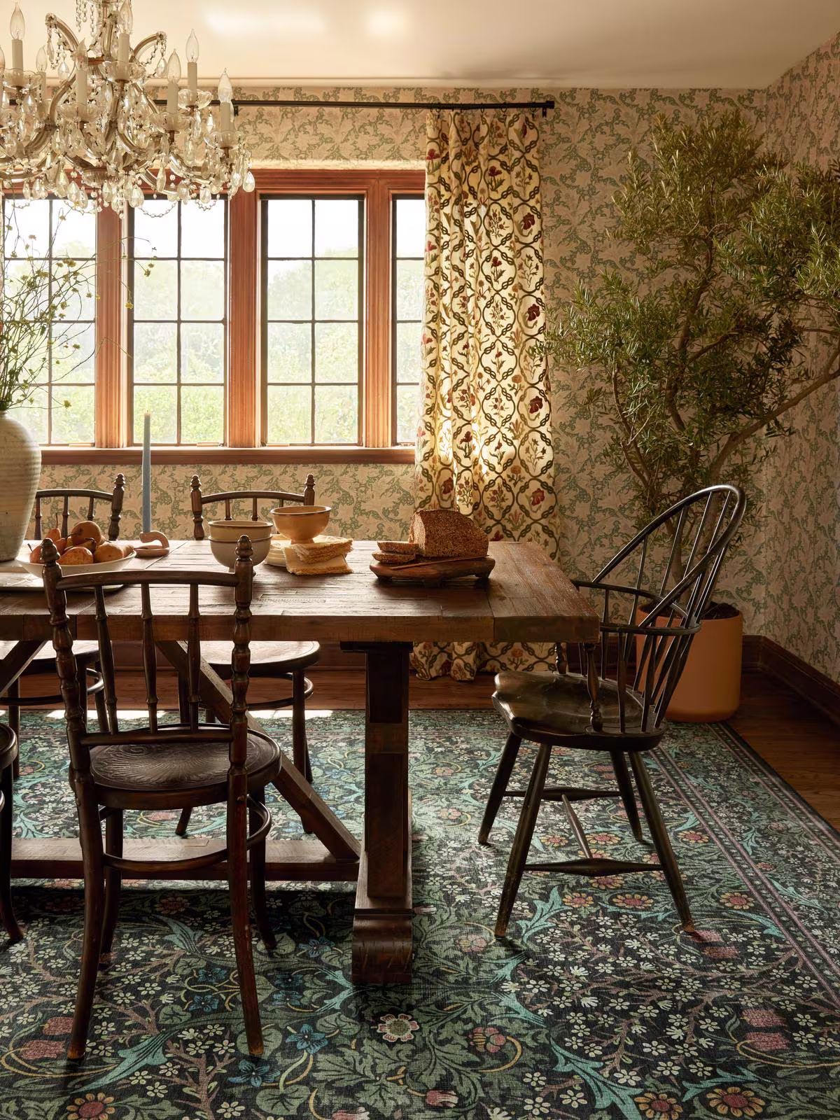cottage dining room with rustic furniture, vintage chandelier, and Ruggable x Morris & Co. Blackthorn Forest Green washable rug