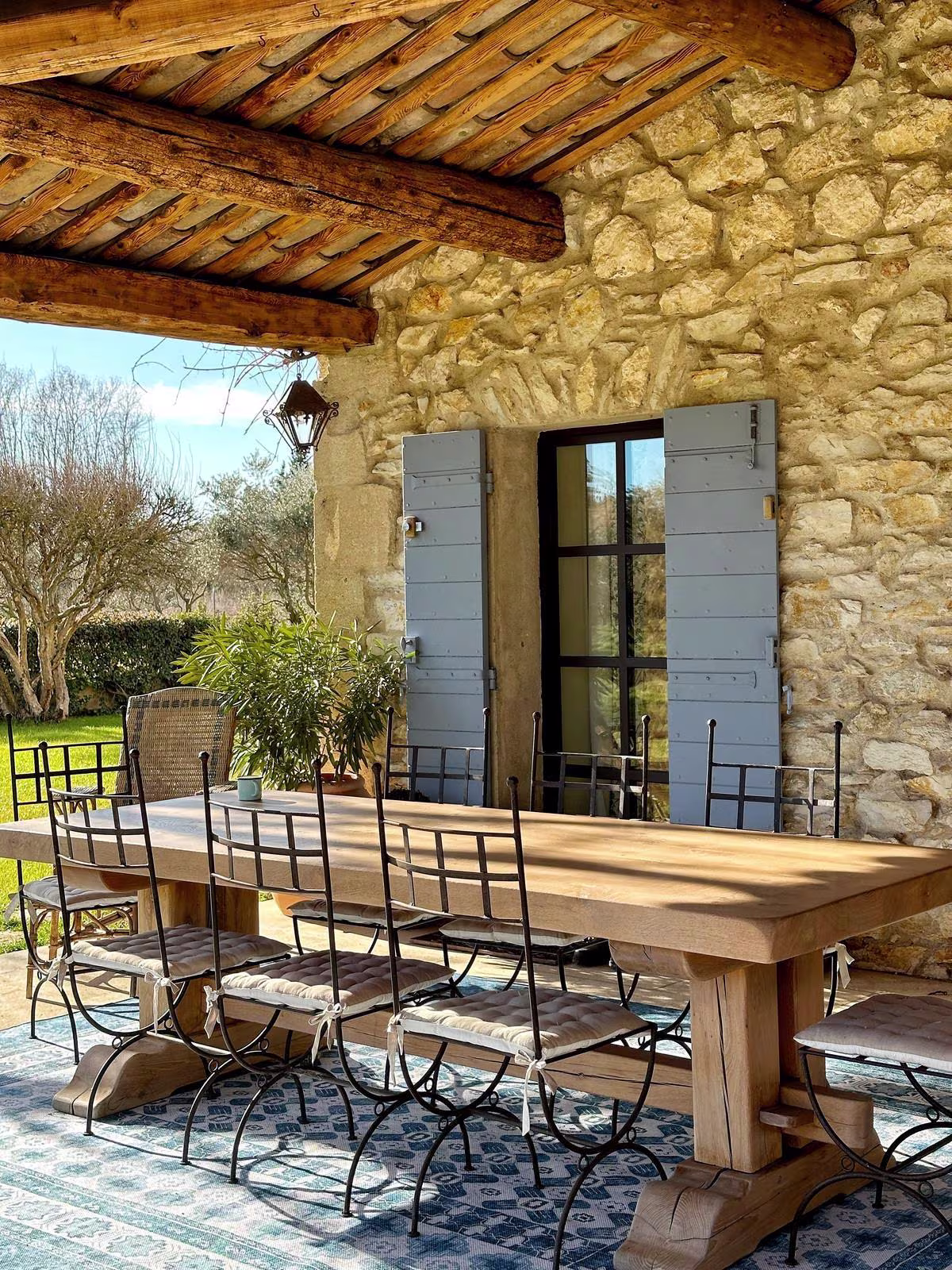 Rustic French patio with washable Ruggable Outdoor Cyrus Ocean & Ivory Rug and dining area
