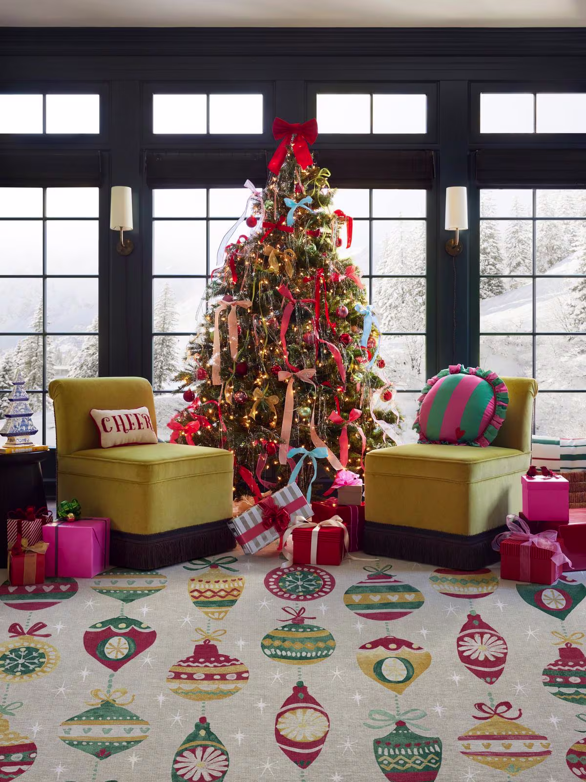 Image of a cozy living room with snow outside and a tall Christmas tree with lots of bows tied, and the Ruggable Festive Garland Holiday Shortbread Rug underneath. 