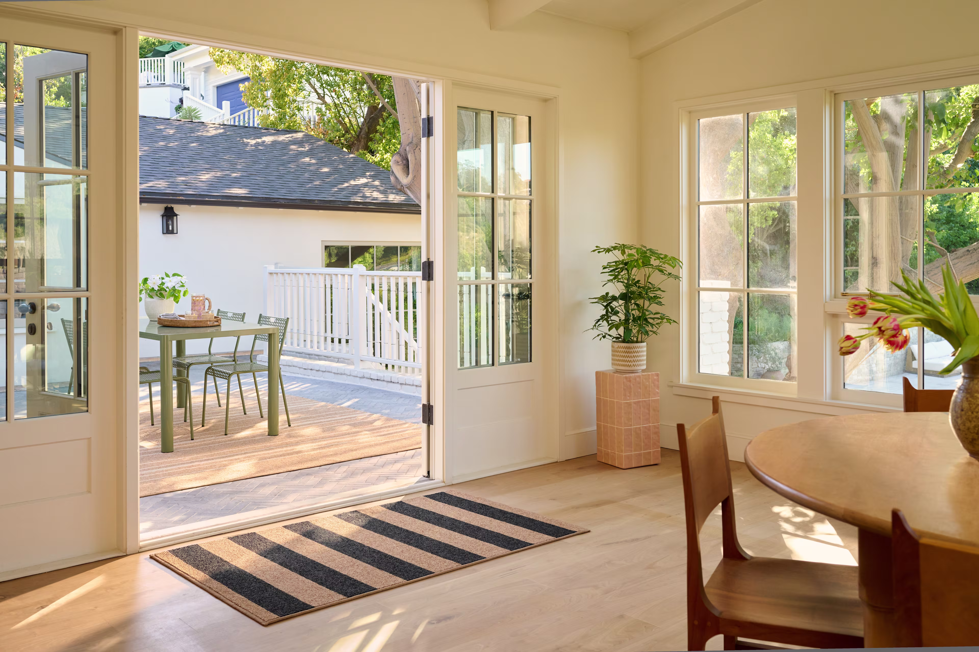 Machine-washable striped doormat at an open patio door, styled for an indoor outdoor entryway with natural light and high-traffic use