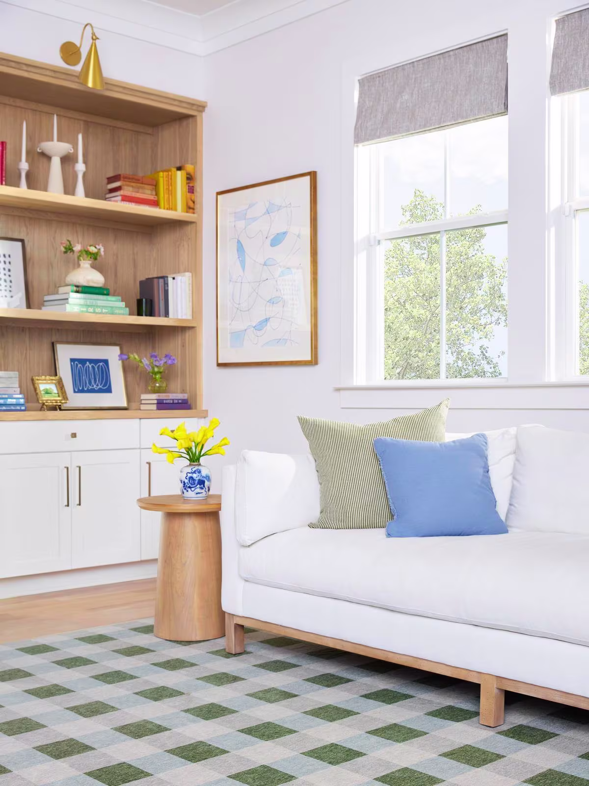 Bright, colorful, and coastal living room featuring the washable Ruggable x The Home Edit Sutton Moss Green & Blue Rug and a bright white West Elm sofa