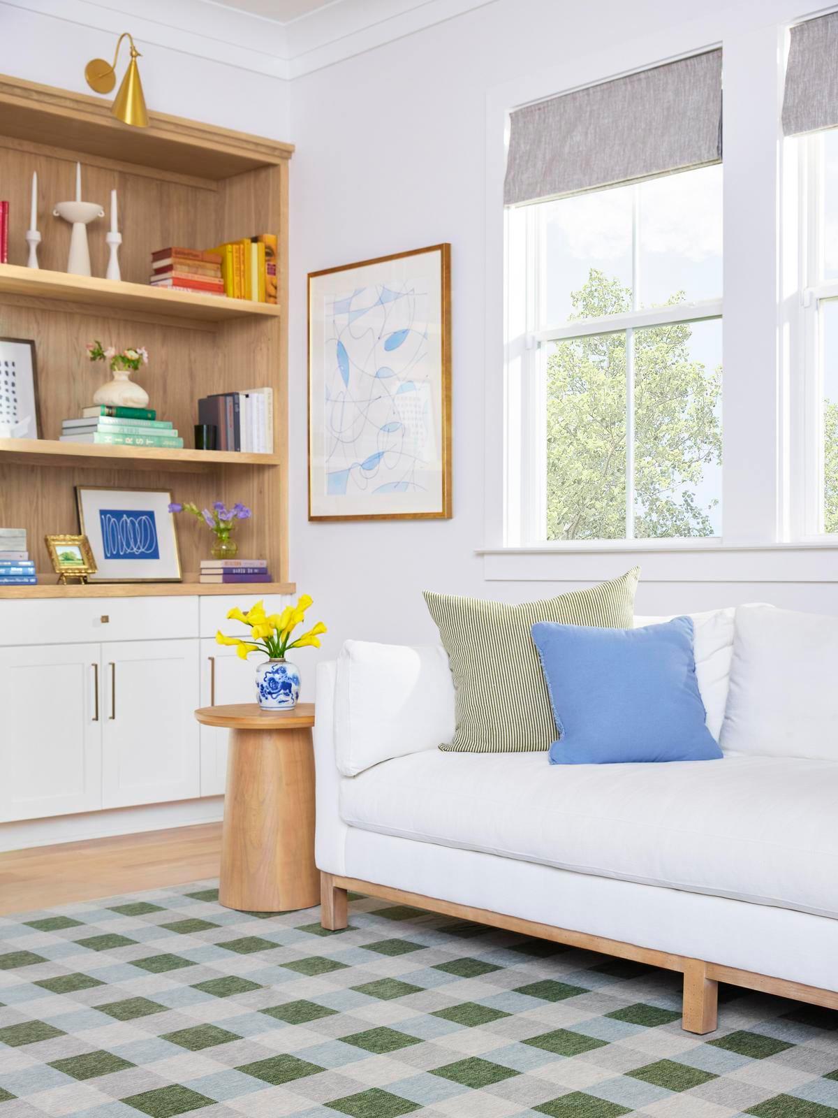 Bright, colorful, and coastal living room featuring the washable Ruggable x The Home Edit Sutton Moss Green & Blue Rug and a bright white West Elm sofa