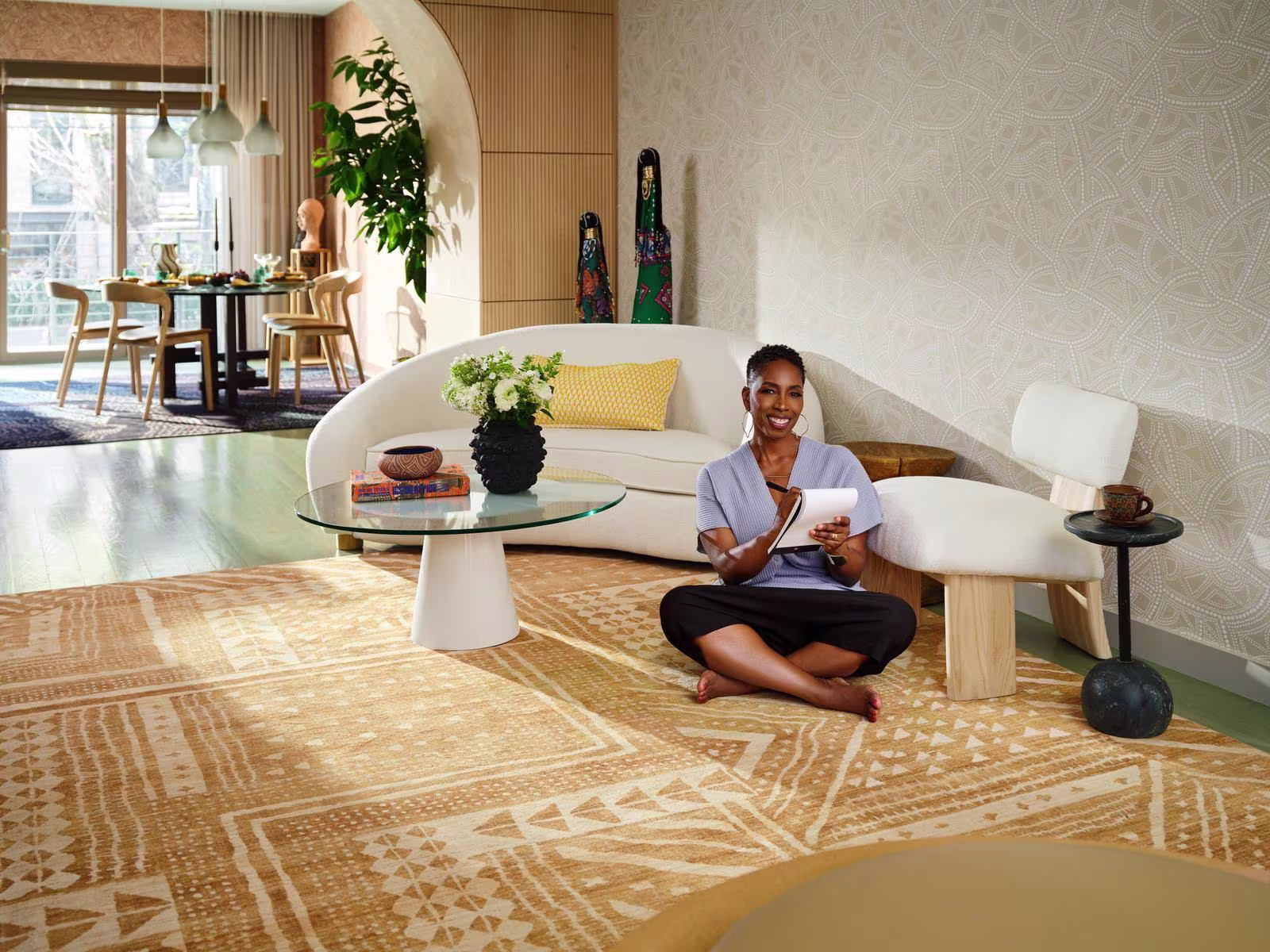 Malene Barnett atop a rug from her Ruggable collection of washable rugs in her African artisan-inspired home