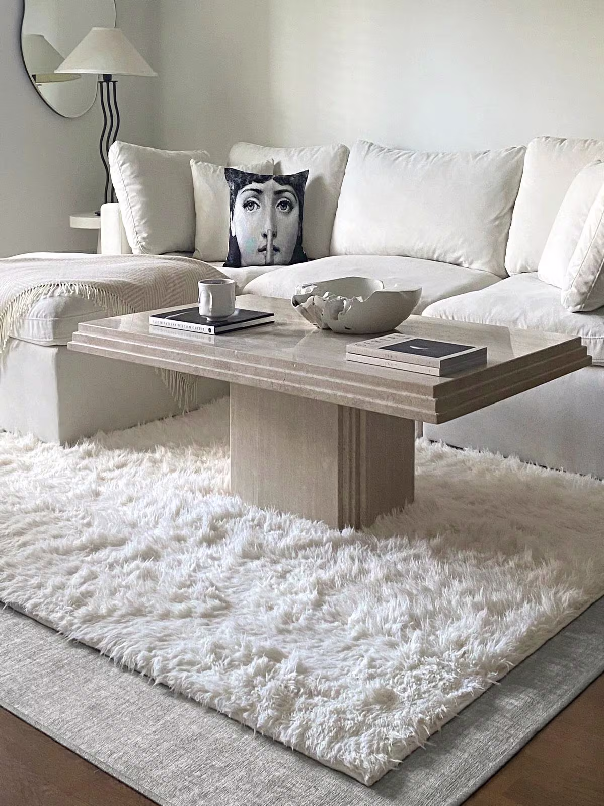 Image of a living room featuring two rug textures layered on top of one another: a flatwoven Crosshatch Beige Ivory Rug with a Egret White Shag Rug.