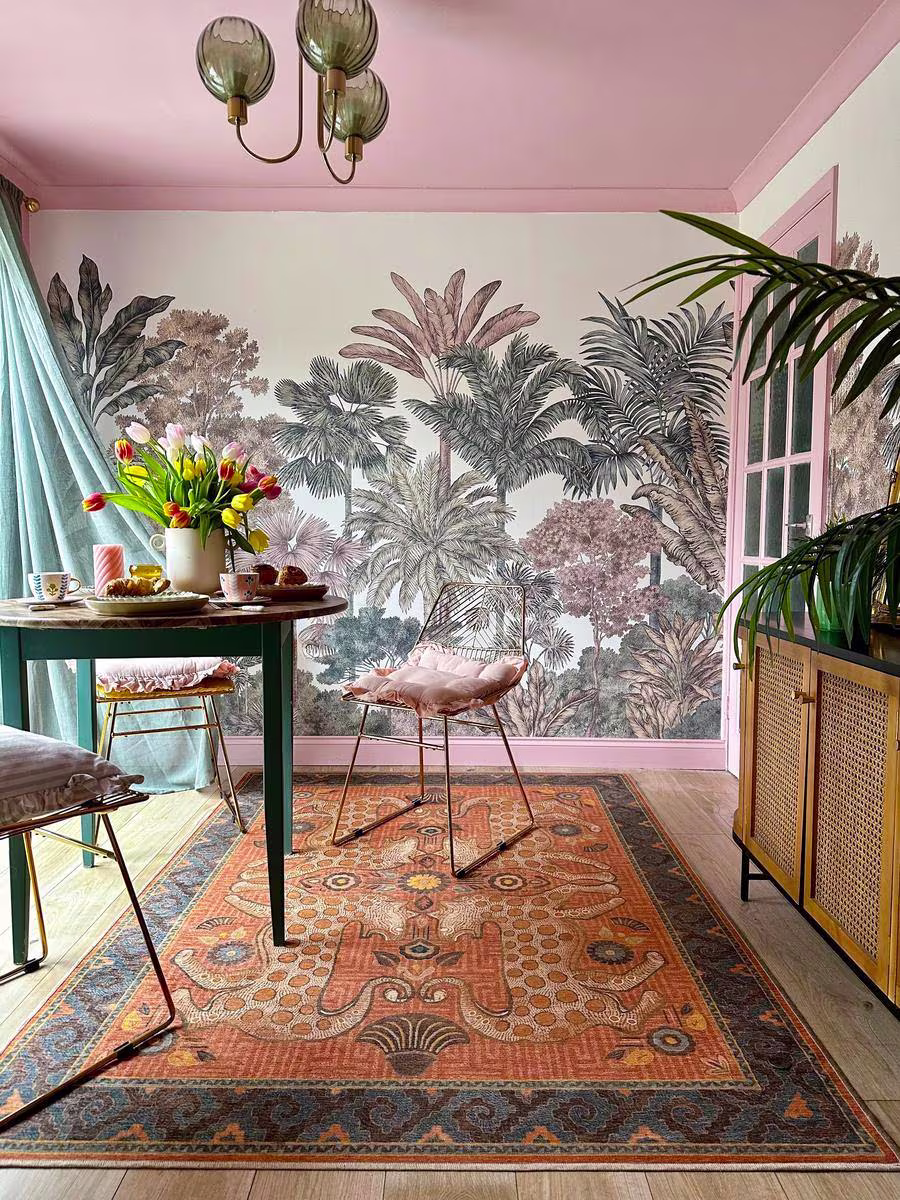 Tropical dining room with Ruggable x Justina Blakeney Eartha Terracotta rug, sheer curtain blowing in the wind, pink trim and ceiling, and cane sideboard by the_shoestring_home