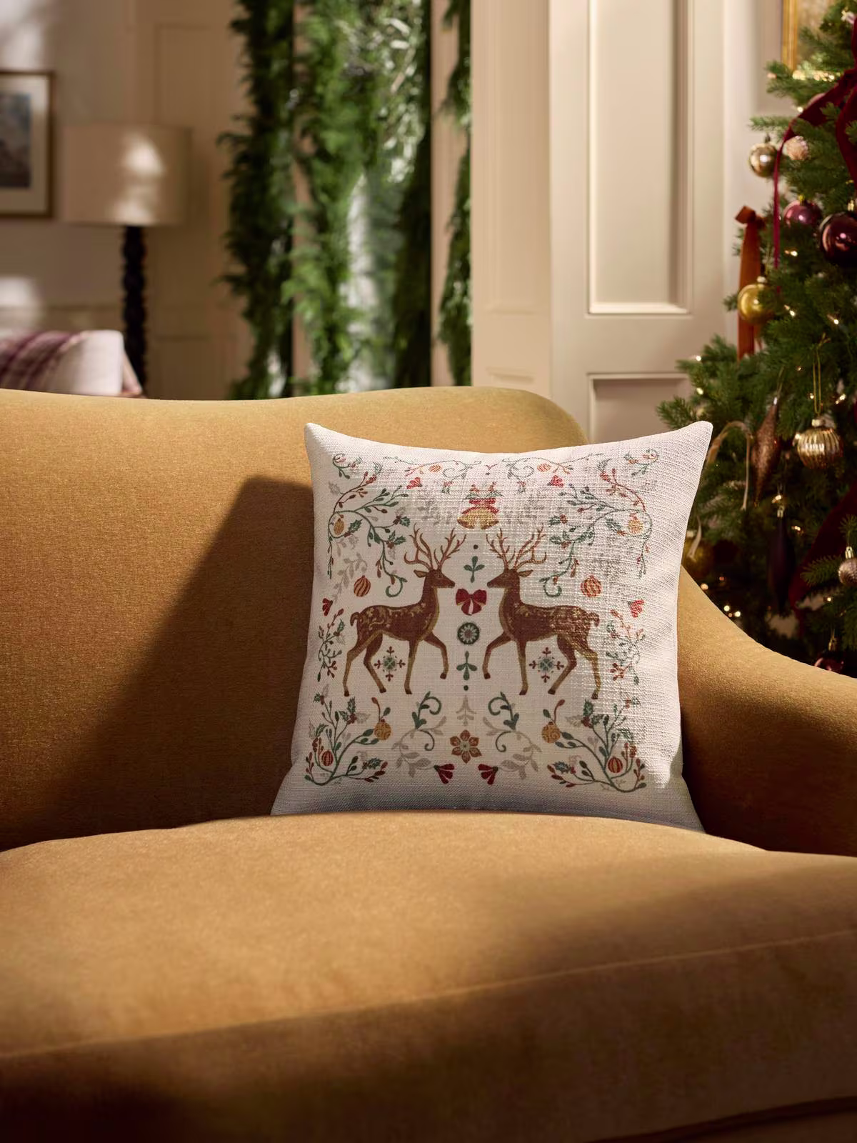 Image of a cozy, golden yellow velvet couch with Ruggable's Ruggable Belle Ivory Woven Throw Pillow. 