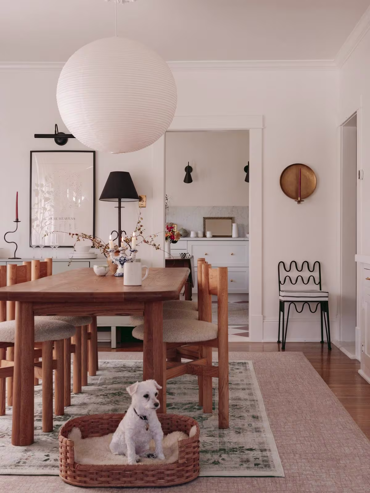 Image of a dining area featuring a larger neutral rug and a smaller, sage-colored rug layered on top. 