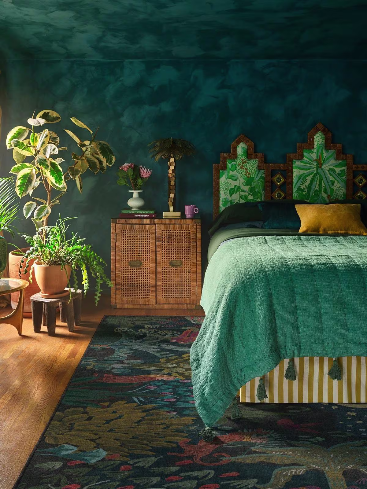 Image of plant-filled bedroom with dark teal walls and bedding, with the Ruggable x Justina Blakeney Josephine Midnight Rug.