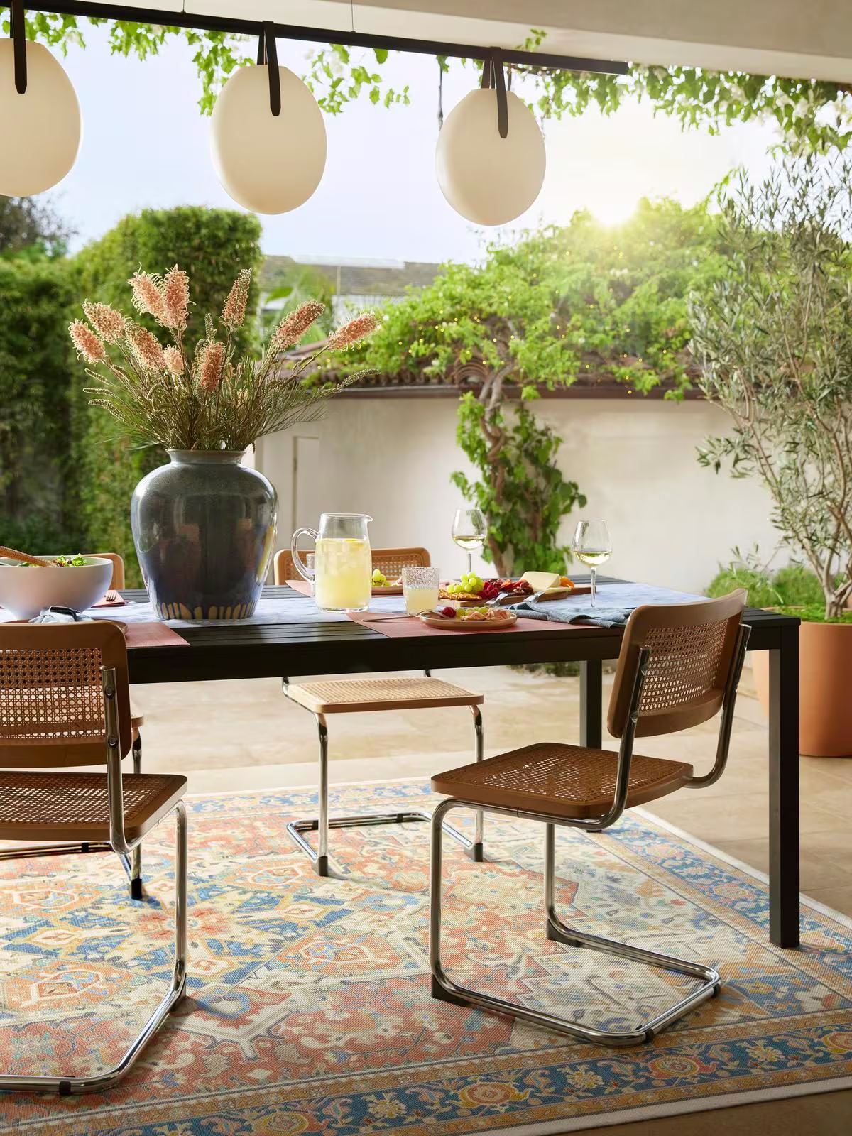 Ruggable Outdoor Kamran Sunset Orange Rug under outdoor dining table in warm weather