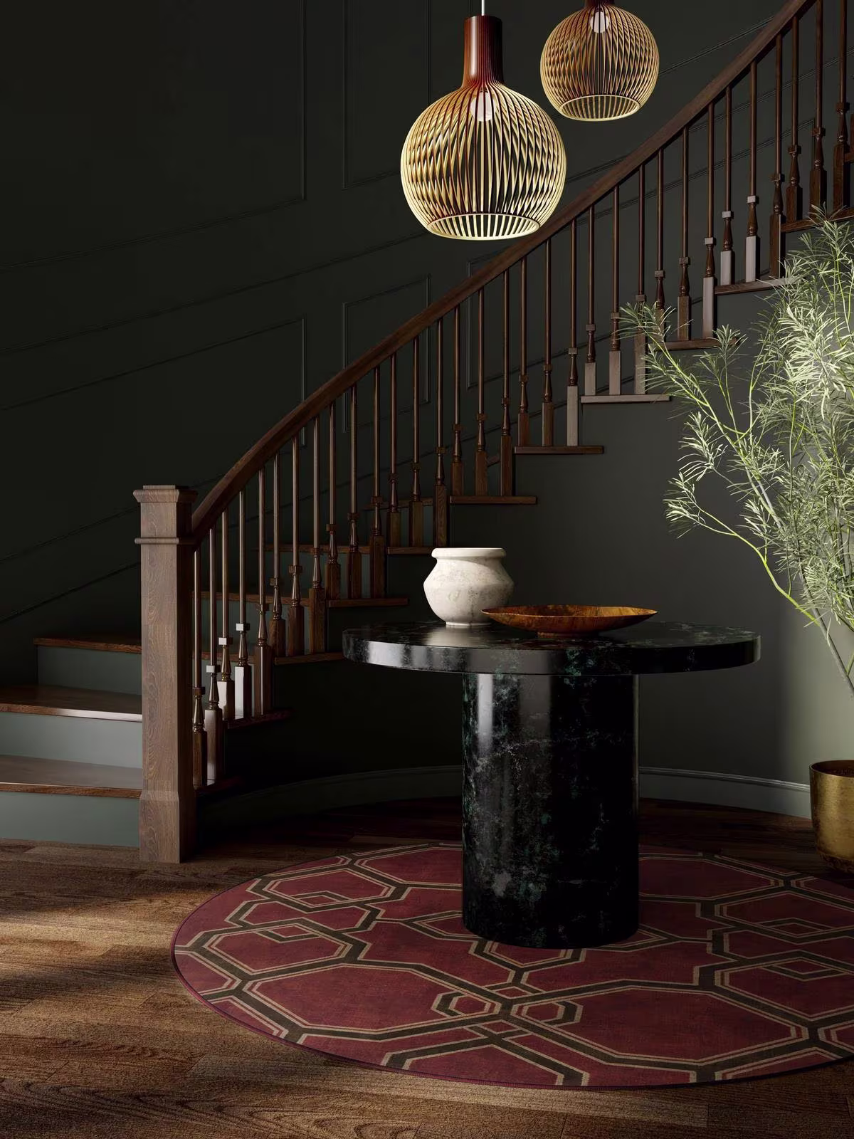 Image of a moody foyer with dark sage-colored walls, a dark wood staircase, circular black marble table, and the Ruggable x Martyn Lawrence Bullard Kian Red Rug. 