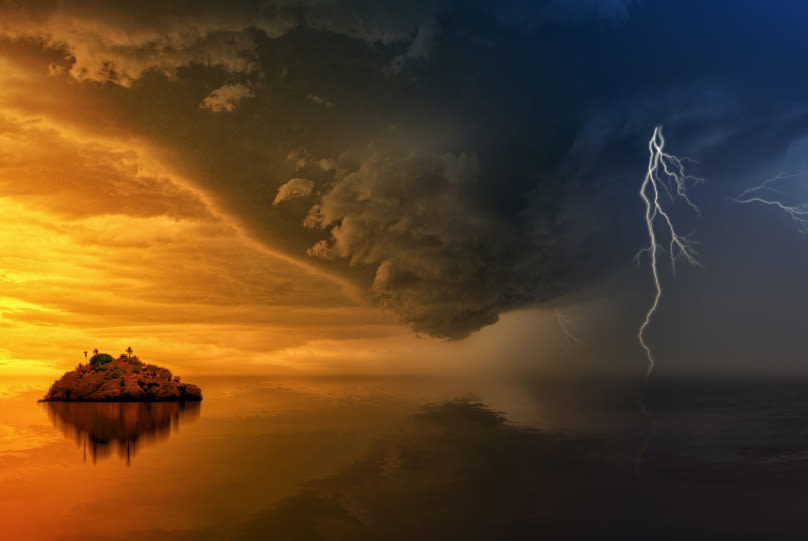 a storm is coming over a small island in the middle of the ocean