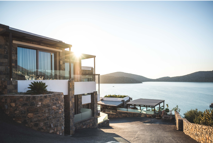 a house on a hill overlooking a body of water.