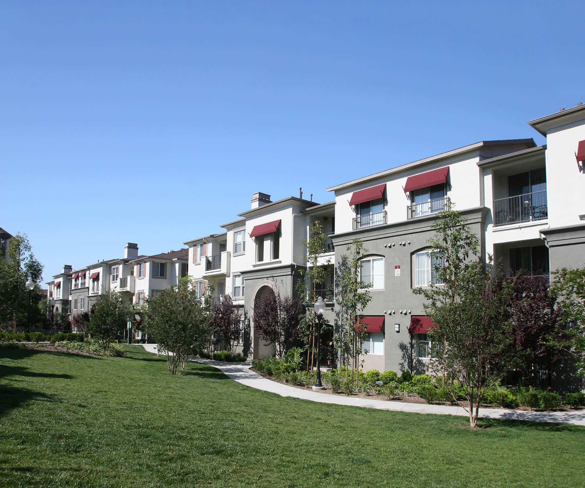 Garden-style multifamily community in Orange County with landscaped paths, balconies, and open green space—designed for suburban residential living.
