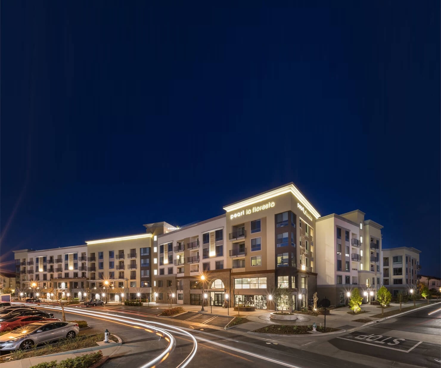 Mixed-use multifamily building in Orange County with illuminated signage and active street frontage.