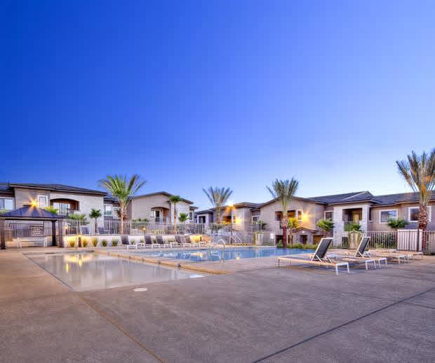 Contemporary multifamily community in Las Vegas featuring a resort-style pool, palm trees, and desert-inspired architecture for lifestyle-focused living.