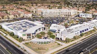 Aerial view of a mixed-use development in California featuring apartments, Whole Foods, and retail—showcasing Juno’s experience in large-scale, multifamily projects.
