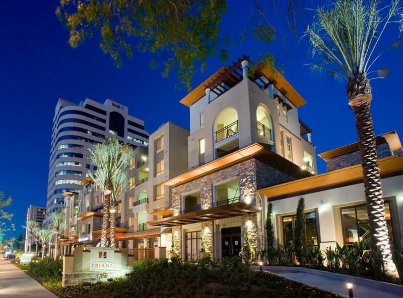 Mediterranean-inspired multifamily development in Los Angeles with palm-lined sidewalks and upscale finishes in a dense, urban employment hub.