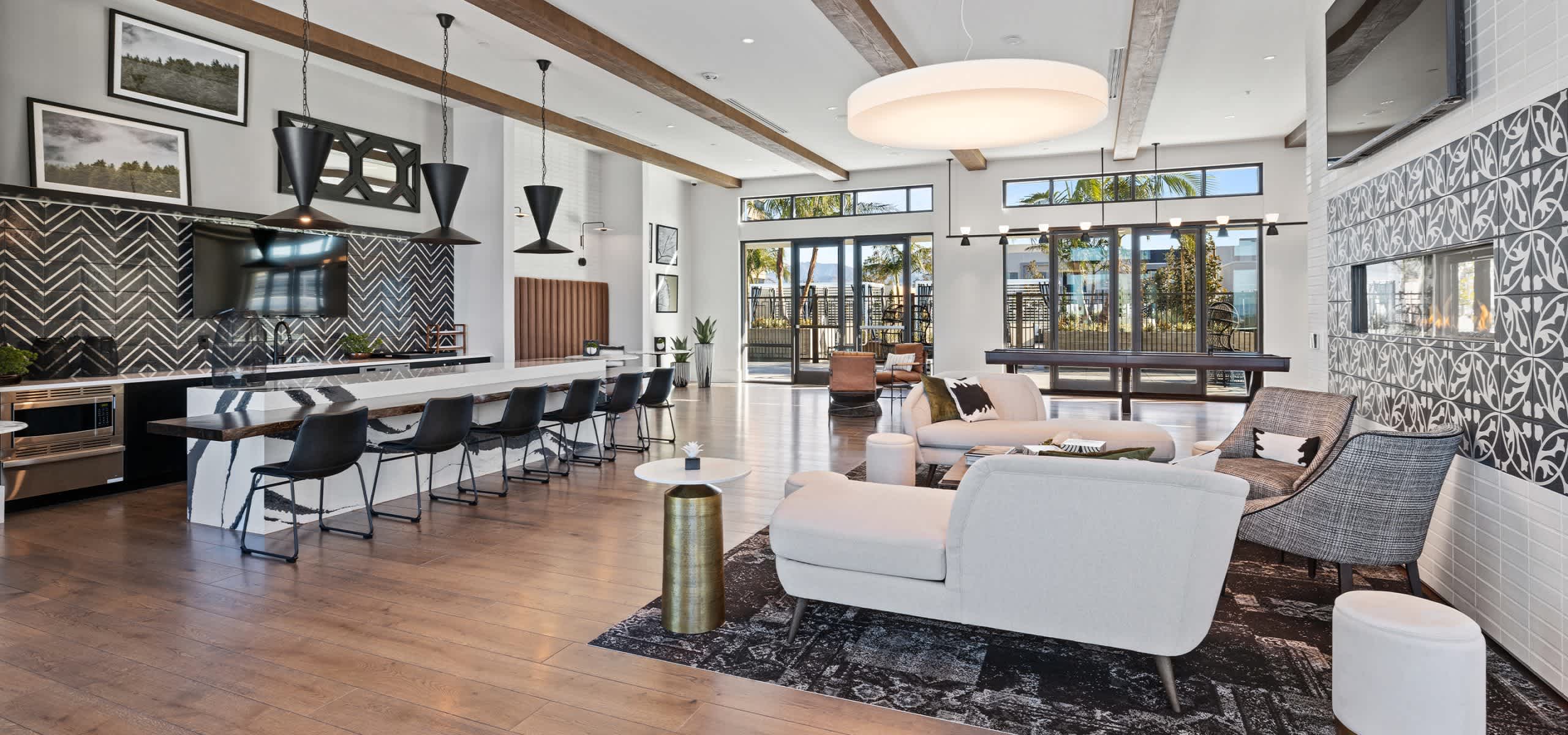 Amenity lounge with designer furnishings, fireplace, and open-concept kitchen at The Grant.