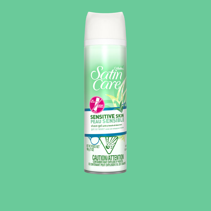 Gillette Venus Satin Care Sensitive Skin shaving gel can on a green background.