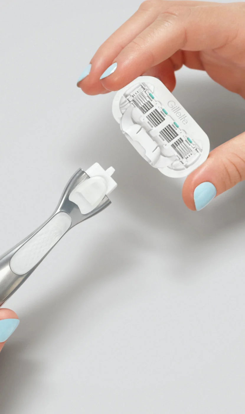 A woman hand holding Gillette Venus blade refills.