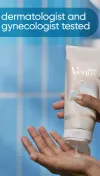 Woman pressing product out of a white Venus Smooth skin exfoliant container into her hand