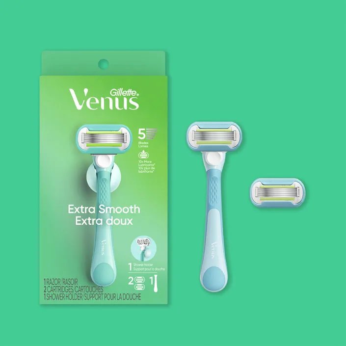 Gillette Venus Extra Smooth razor pack with handle and two refill cartridges on green background