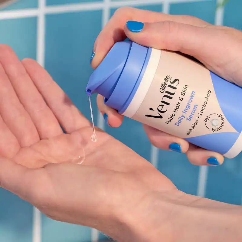 Feminine hand holding daily soothing serum in the bathroom